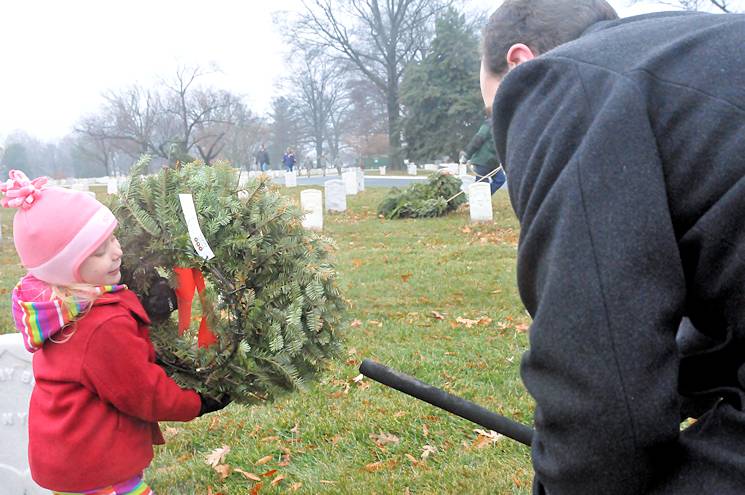 Abby Fries, age 4, helps her father, Theran, clear remembrance wreaths from Arlington National Cemetery on Jan. 22, 2015. Volunteer service can help build and enhance careers for service members transitioning out of the service, according to Joint Base Myer-Henderson Hall's volunteer coordinators. (JBM-HH PAO photo by Jim Dresbach)