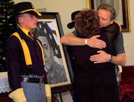Phil Taylor, artist for and founder of The American Fallen Soldiers Project: Portraits of Patriotism, embraces Shirley Chitjian, wife of Cpl. Adam Chitjian, 3rd Battalion, 8th Cavalry Regiment, 3rd Brigade Combat Team, 1st Cavalry Division, who was killed in action in Balad, Iraq, Oct. 25, 2007, after presenting her a portrait of her husband during a memorial ceremony at the 58th Street Chapel.