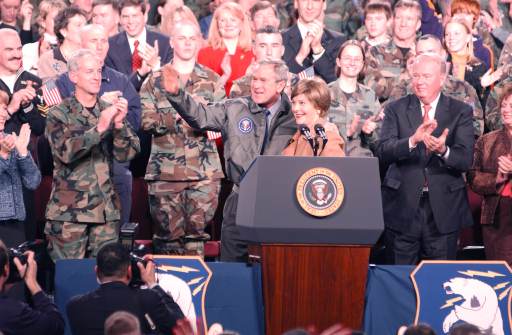 President George W. Bush, with First Lady Laura Bush by his side, waves to personnel at Elmendorf Air Force Base, Alaska, during his visit Nov. 14, 2005.
