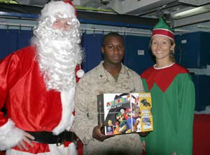 Cpl. Bill L. Gainey, radio operator, R Battery, Battalion Landing Team 1st Battalion, 4th Marine Regiment, Camp Pendleton, Calif., show’s off the Nintendo GameCube video game system he won during a holiday party raffle aboard the USS Peleliu Dec. 11.