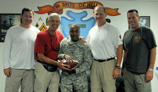 Army Command Sgt. Maj. Wilson L. Early, 36th Infantry Division, poses with professional football head coaches (left to right) Jim L. Mora, Jim E. Mora, Ken Whisenhunt and Gary Kubiak during their visit to Contingency Operating Base Basra, July 4, 2011. COB Basra was the last stop of a tour of military bases in Kuwait and Iraq sponsored by the National Football League and the United Services Organization. Photo by Army Pvt. Andrew Slovensky